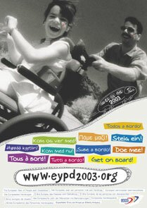 photo campagne: un homme pousse une fillette en chaise roulante; tous deux sourient